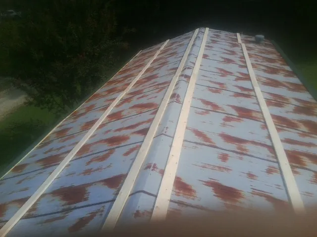 Rusted metal roof panels with new wood purlins before replacement — Storm Damage Roof Repair in Pearl by Roofing Brothers