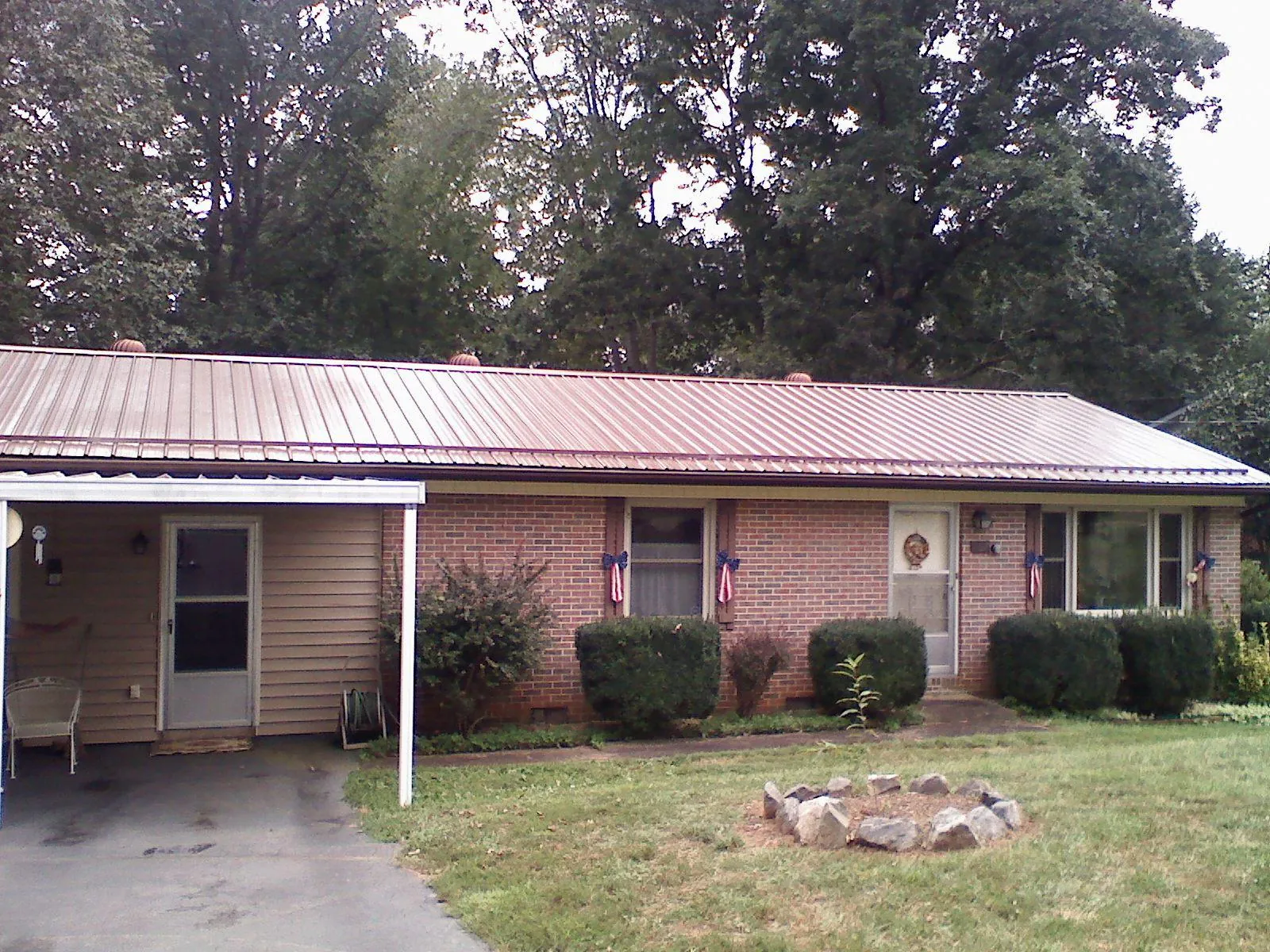 Bronze metal roof and carport on a brick ranch home — Roof Repair work by our crew in Pearl